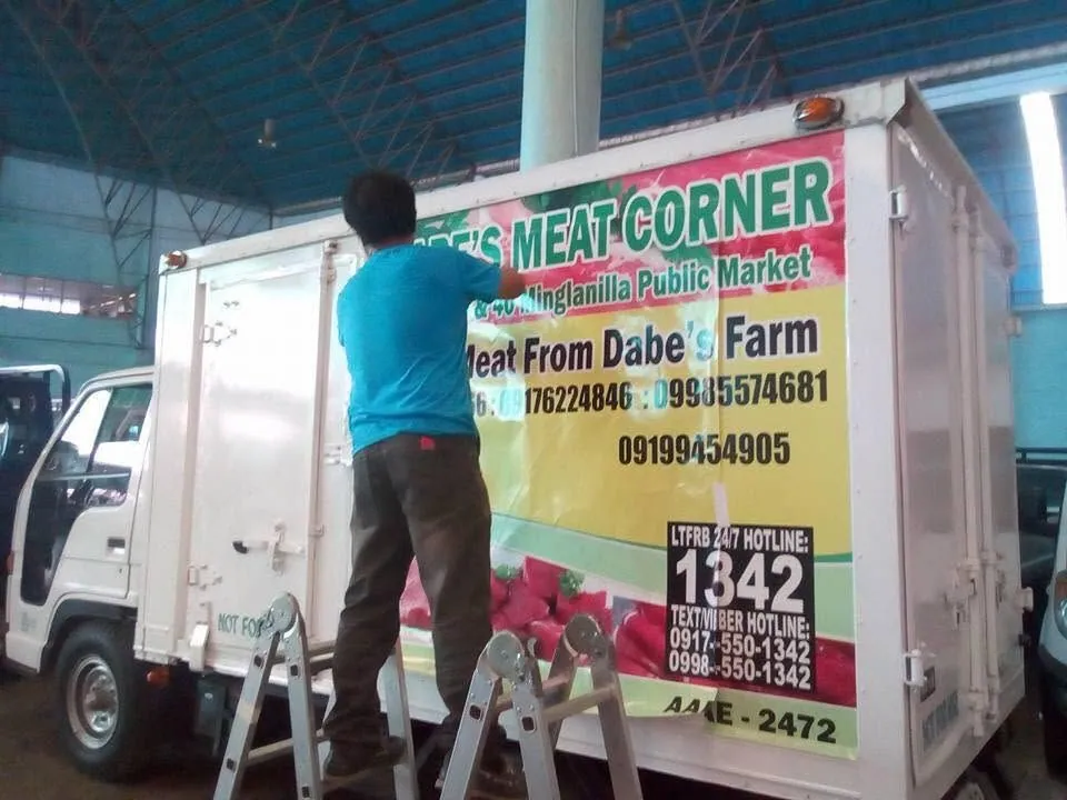 MCAV crew installing a Dabe's Meat Corner vehicle wrap