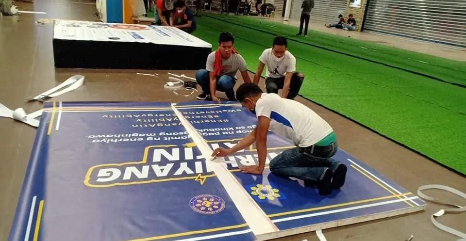 MCAV crew installing an Enerhiyang Atin standee