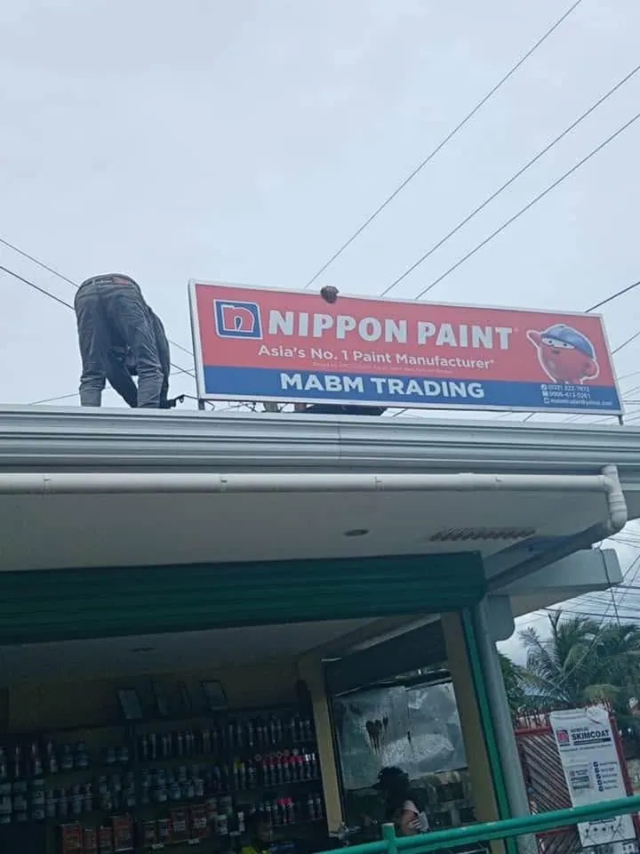 MCAV crew installing a Nippon Paint Panaflex sign