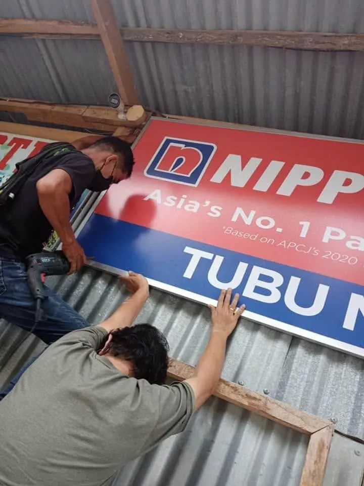 MCAV crew installing a Nippon Paint Panaflex sign