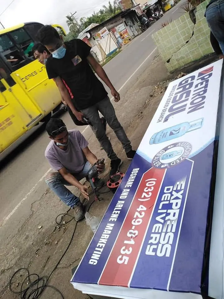 MCAV crew installing a Petron Panaflex sign