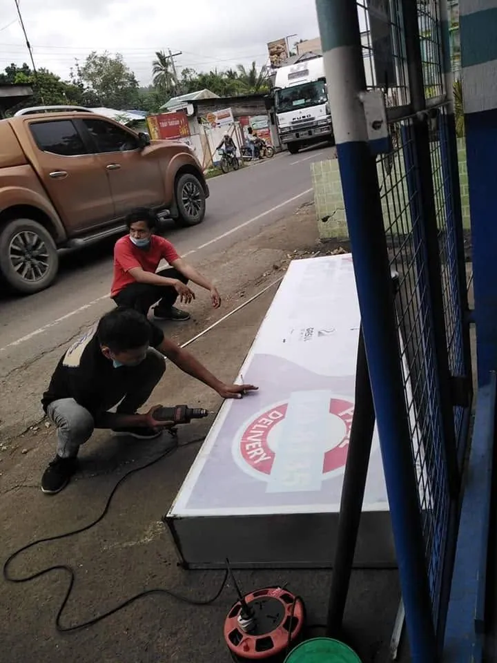 MCAV crew installing a Petron Panaflex sign