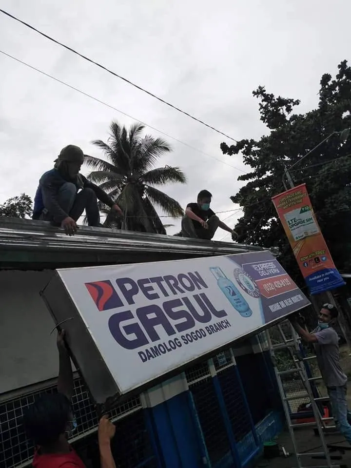 MCAV crew installing a Petron Panaflex sign at Damolog, Sogod, Cebu