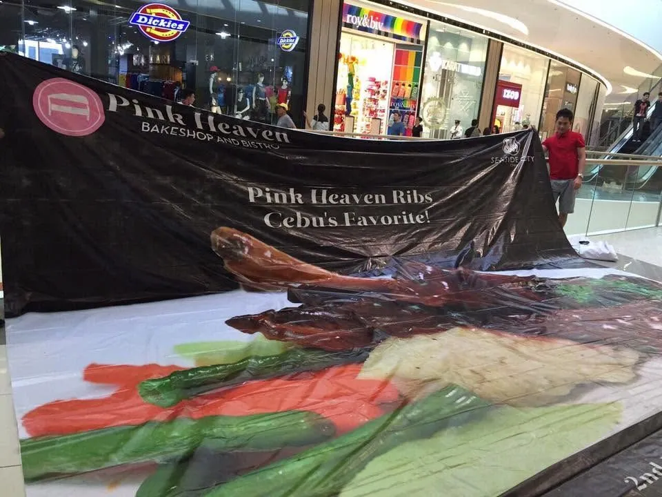MCAV crew installing a Pink Heaven Bakeshop and Bistro tarpaulin at SM Seaside City Cebu